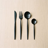 Spain Set — matte black flatware on a warm wood table