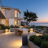 Block Lane Outdoor Solar Light lighting an outdoor dining terrace at dusk