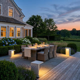 Block Lane Outdoor Solar Light lighting an outdoor dining terrace at dusk