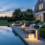 Block Lane Outdoor Solar Light lining a poolside terrace at dusk