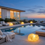 Vibrant Stone Outdoor Light lining a poolside terrace at dusk