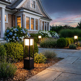 Nimbus Cube Solar Light glowing among garden planting at dusk