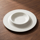 Solis Soup Plate — sculptural gallery view on a warm wood table