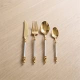 Noble Golden Cutlery Set — ornate gold flatware on a warm wood table