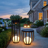 Flower Pot Lamp outdoor solar lantern in matte black, tall planter and low side-table sizes lit on an estate terrace at dusk