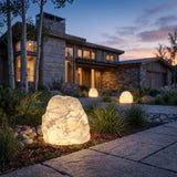 Garden Stone Outdoor Light glowing among garden planting at dusk