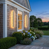 Stripe Lined Wall Light mounted on an exterior wall, washing the surface with warm light at dusk