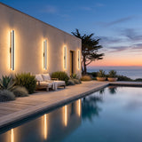 Stripe Lined Wall Lights on a pool house wall, reflected in the water at dusk