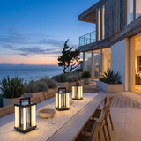 Contemporary Lamp lanterns lighting an outdoor dining table at dusk