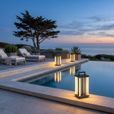 Contemporary Lamp lanterns set along a pool edge at dusk