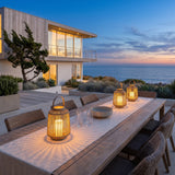 Lantern Sora Weave lanterns lighting an outdoor dining table at dusk