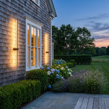 Luminous Line Outdoor Light mounted on an exterior wall, washing the surface with warm light at dusk