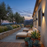 Sunset Wall Light mounted above outdoor lounge seating at dusk
