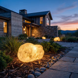Vibrant Stone Outdoor Light glowing among garden planting at dusk