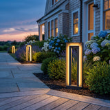 Prism Pathway Light (Outdoor Solar) glowing among garden planting at dusk