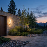 Marble Outdoor Wall Light mounted on a garden wall above planting at dusk